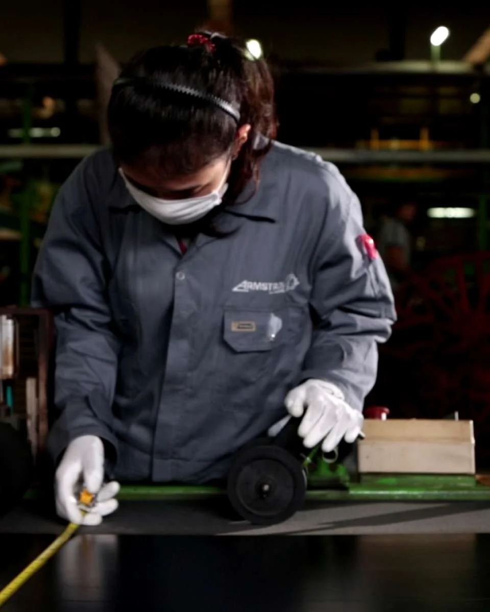 A technician measuring a tyre in a factory